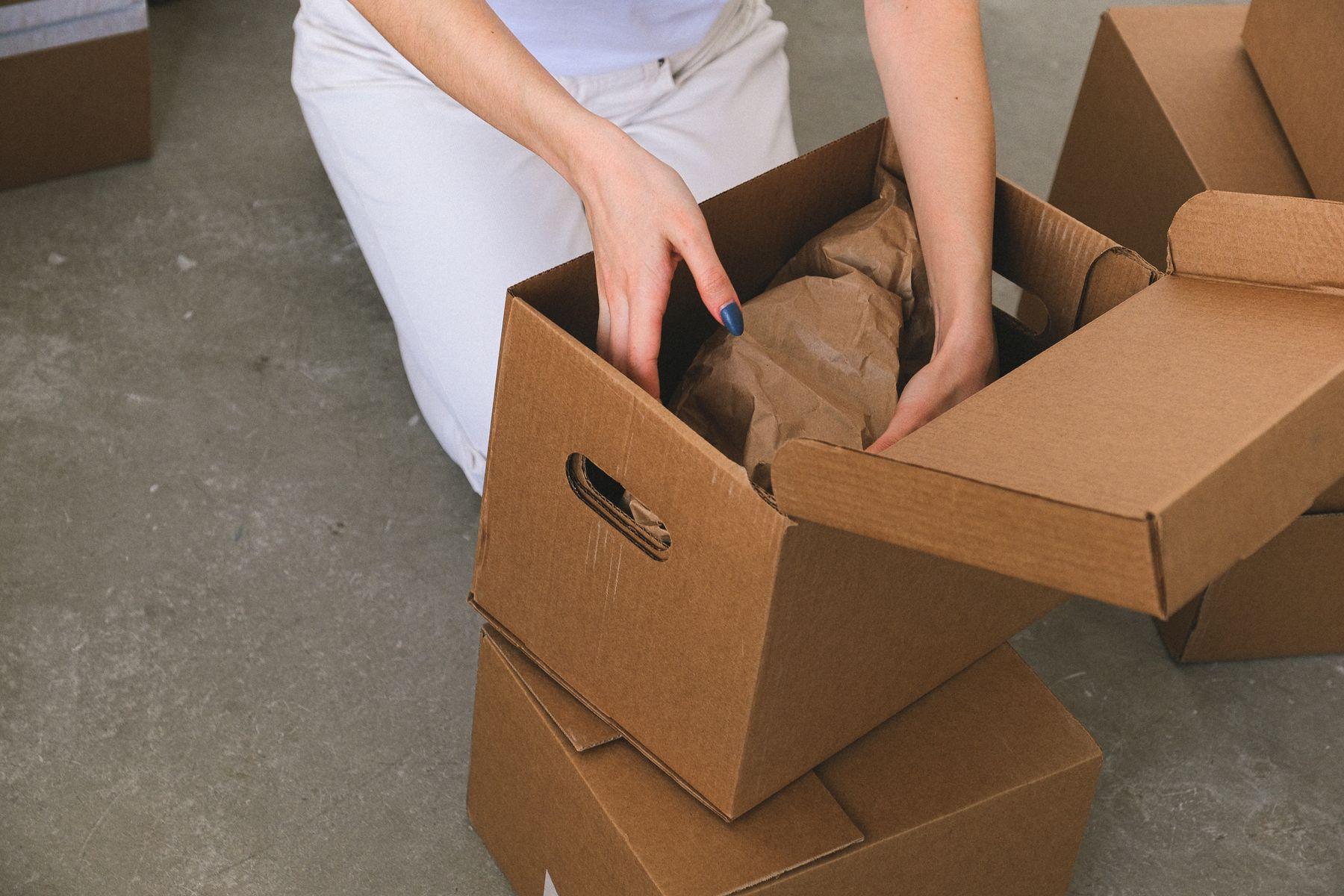Hands carefully packing protected belongings into a moving box